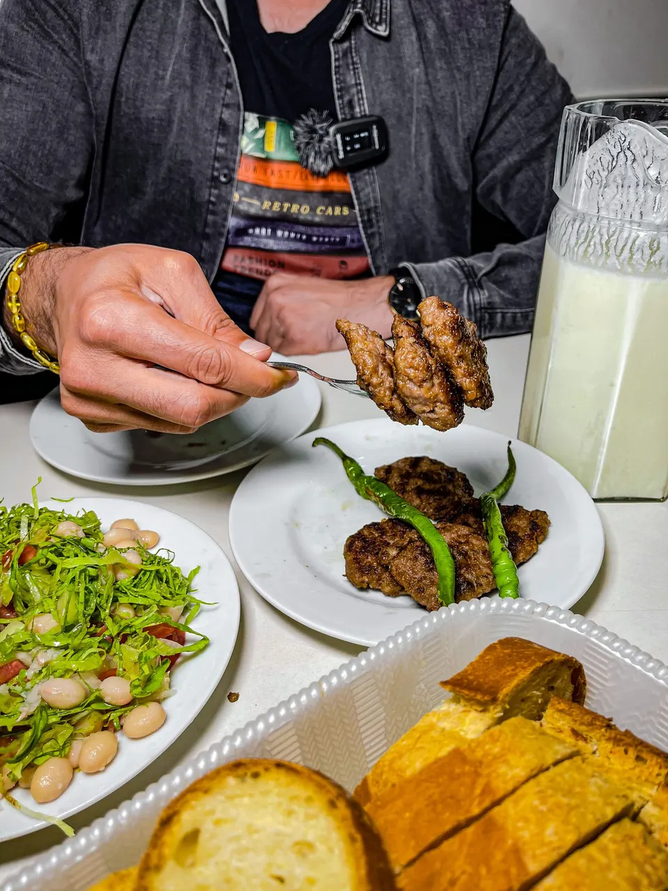 Masada ızgara köfte, fasulye piyazı, ekmek ve ayran sürahisi
